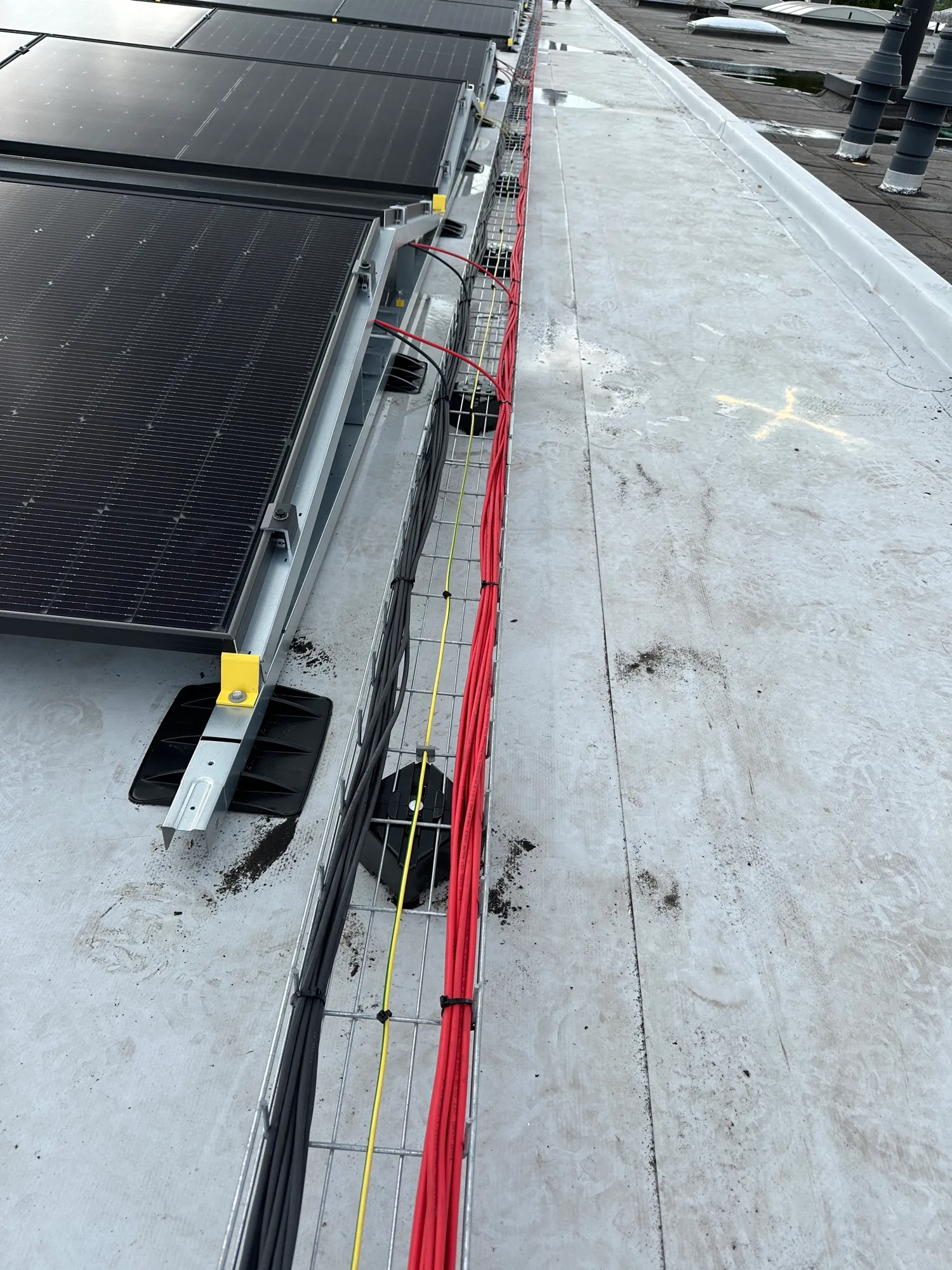 Nette kabelgoten en bekabeling van een zonnestroominstallatie op een plat dak